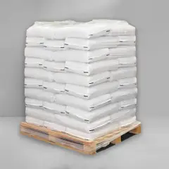 Stos białych worków cementu na drewnianej palecie, owinięty folią.