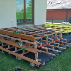 Budowa tarasu na słupach betonowych. Drewniana konstrukcja czeka na deski.