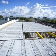 Budowa dachu z prefabrykowanych elementów, ukazująca różne rodzaje stropów w trakcie montażu.