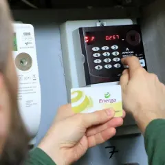 Doładowanie licznika przedpłatowego Energa. Osoba wprowadza kod na klawiaturze urządzenia.