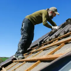 Pracownik na dachu dwuspadowym, szacowany koszt dachu dwuspadowego 200m2.