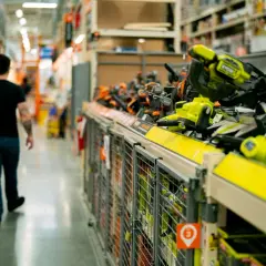 W sklepie z narzędziami, gdzie można dokonać **Castorama zwroty**, mężczyzna idzie alejką pełną elektronarzędzi.