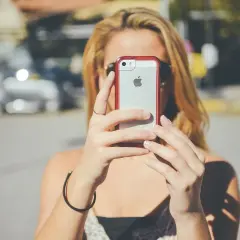 Blondynka z telefonem iPhone próbuje naprawić problem "nie zarejestrowano w sieci".