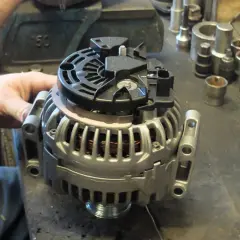 Warsztat samochodowy, gdzie mechanik sprawdza alternator. Zastanawiasz się, ile kosztuje regeneracja alternatora?