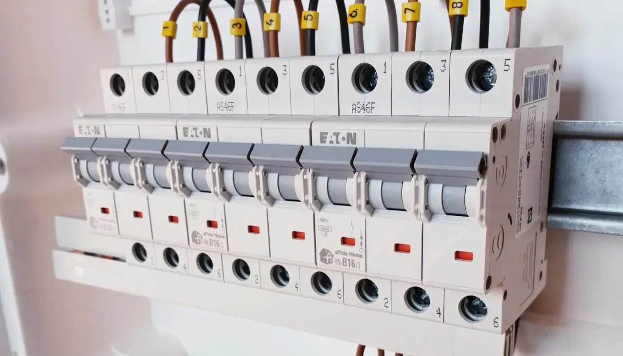 Rozdzielnica elektryczna z wyłącznikami. Jeden z obwodów może być uszkodzony, co sugeruje brak jednej fazy w domu.