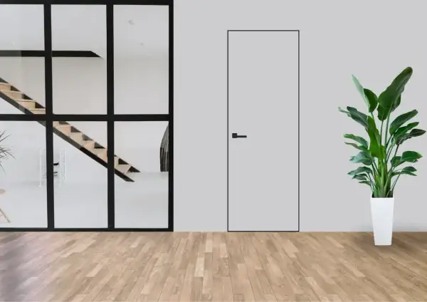Minimalistyczne wnętrze z widocznymi schodami za szklaną ścianą i dyskretnymi drzwiami ukrytymi w ścianie. Obok stoi duża roślina w białej donicy.