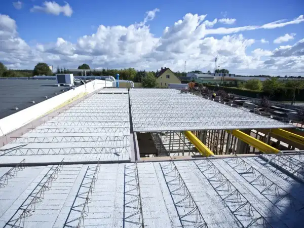Budowa dachu z prefabrykowanych elementów, ukazująca różne rodzaje stropów w trakcie montażu.