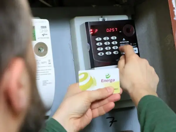 Doładowanie licznika przedpłatowego Energa. Osoba wprowadza kod na klawiaturze urządzenia.