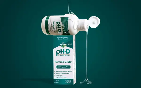 Płynny lubrykant Femme Glide™ z aloesem organicznym, wylewający się z butelki, zapewnia gładkość i komfort.
